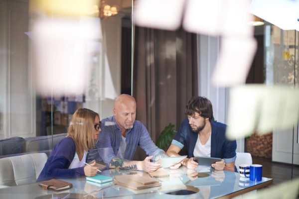 Mature businessman with touchpad presenting his colleagues fresh ideas